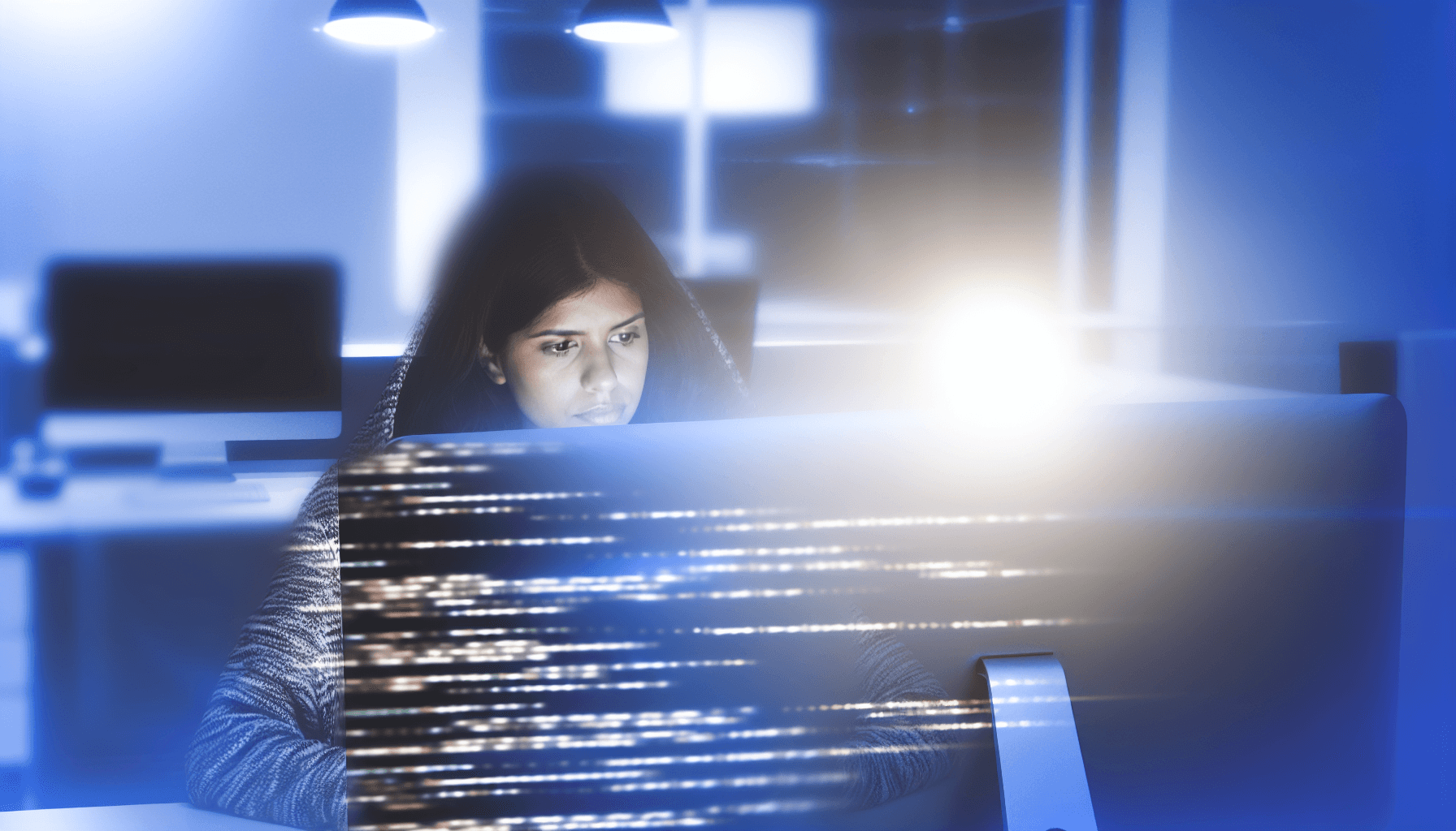 A developer focused on a computer screen with code in a modern workspace, emphasizing concentration and technical skill.