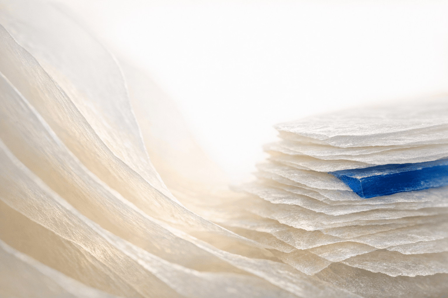 Translucent layered sheets glowing softly against a light background
